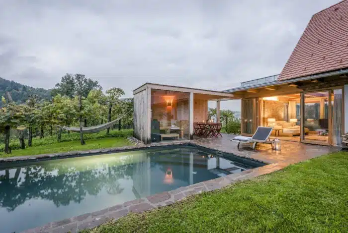Beleuchtetes Haus mit Pool in der Abenddämmerung