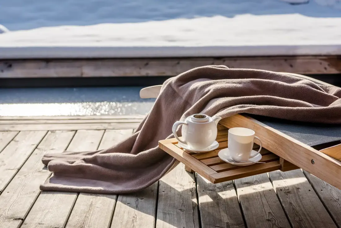 Liegestuhl mit Decke und Teeservice auf der Terrasse
